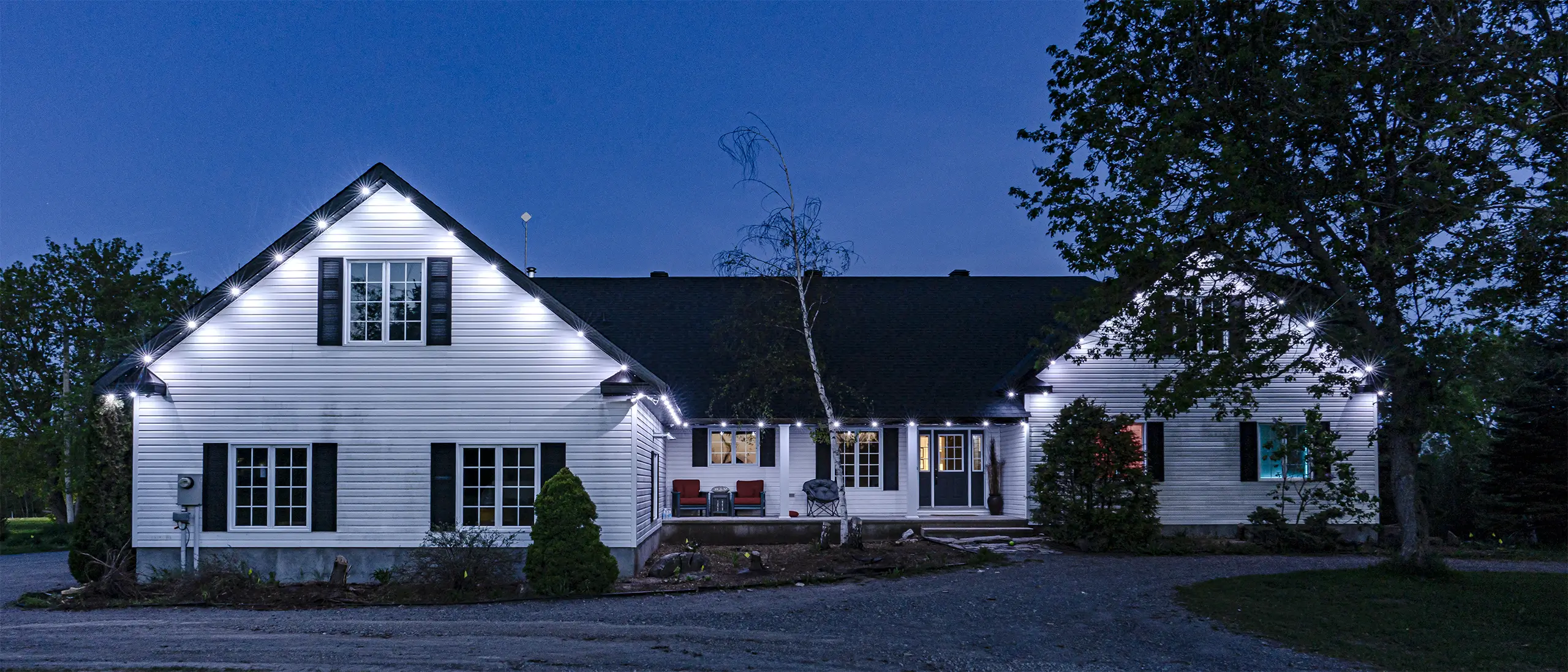 White farmhouse with security lighting illuminating entry points